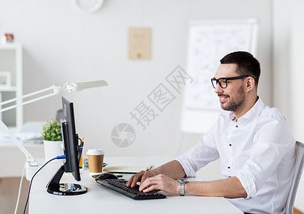 的电脑键盘上打字的眼镜商人办公室电脑键盘上打字计算机高清图片素材